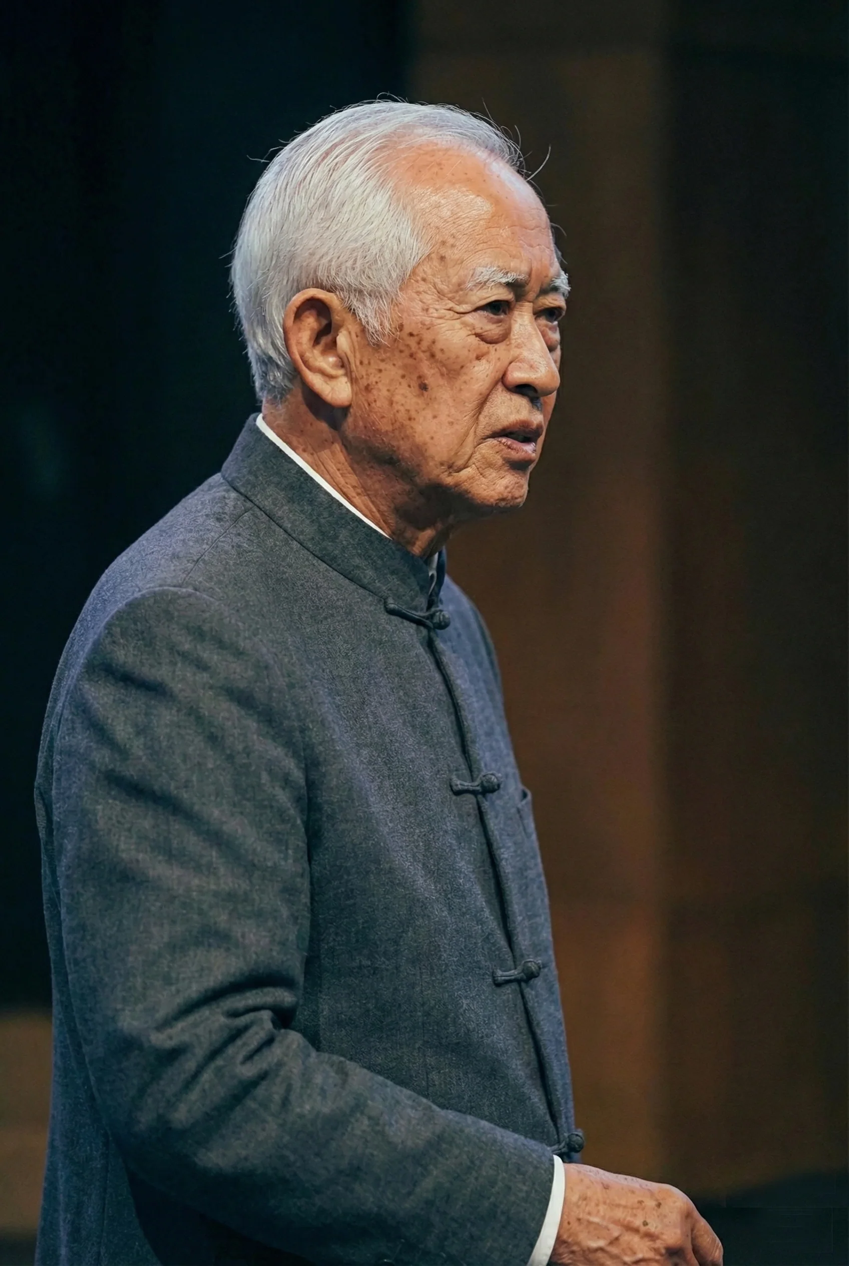 人物在户外以侧视角出镜，脸部轮廓清晰，仍保留足够的五官信息